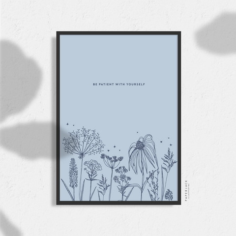 PaperJack Illustrates wall art print in blue and navy with an outline of florals across the bottolsm and the quote - be patient with yourself